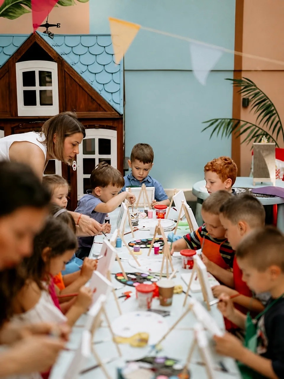 Deca za stolom učestvuju u kreativnoj aktivnosti tokom proslave